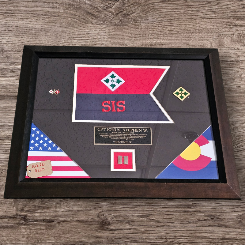 Framed military insignia and flags on a wooden surface