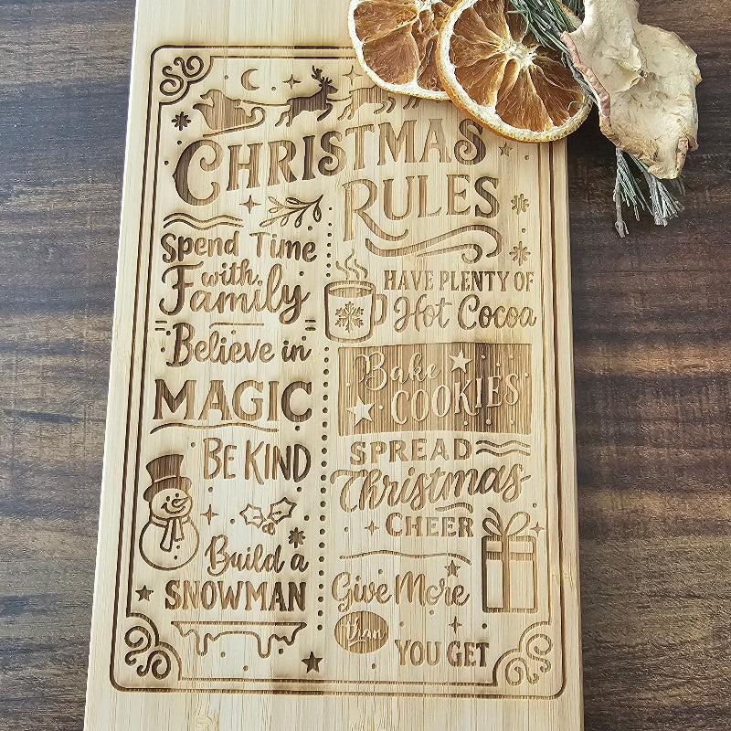 Wooden plaque with engraved Christmas rules on a wooden surface with decorative elements.