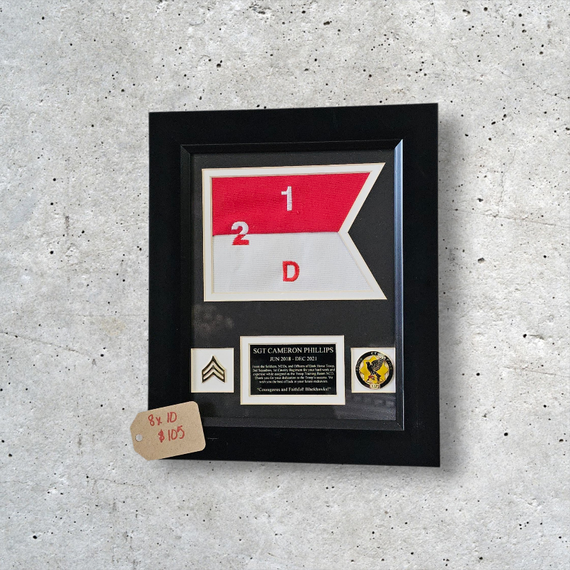 Framed military insignia and documentation on a textured gray surface