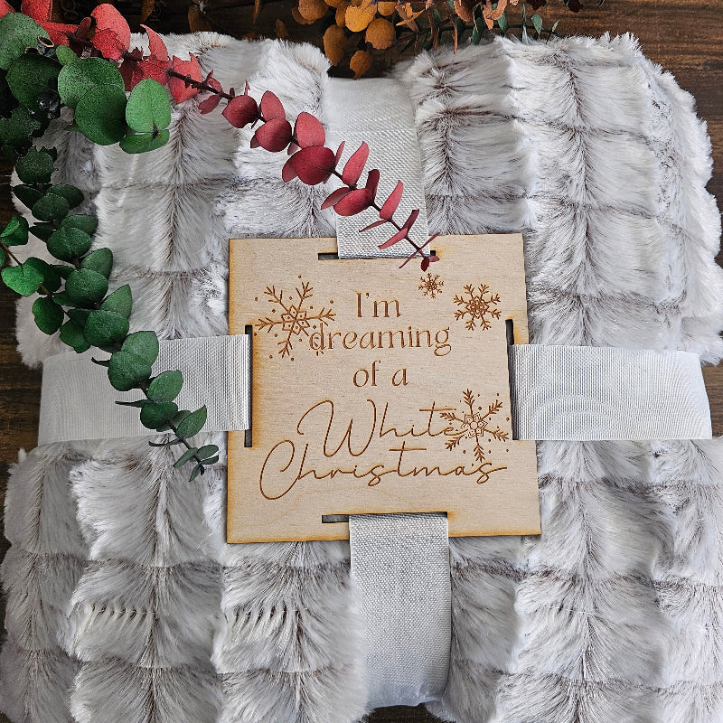 Decorative wreath with text and floral elements on a wooden background