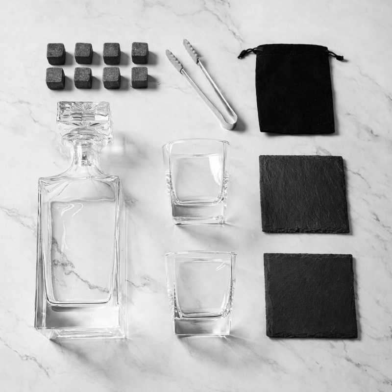 Alcohol decanter set with glasses, coasters, and stones on a marble surface