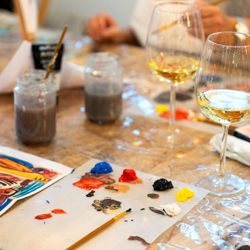 Art supplies and wine glasses on a table