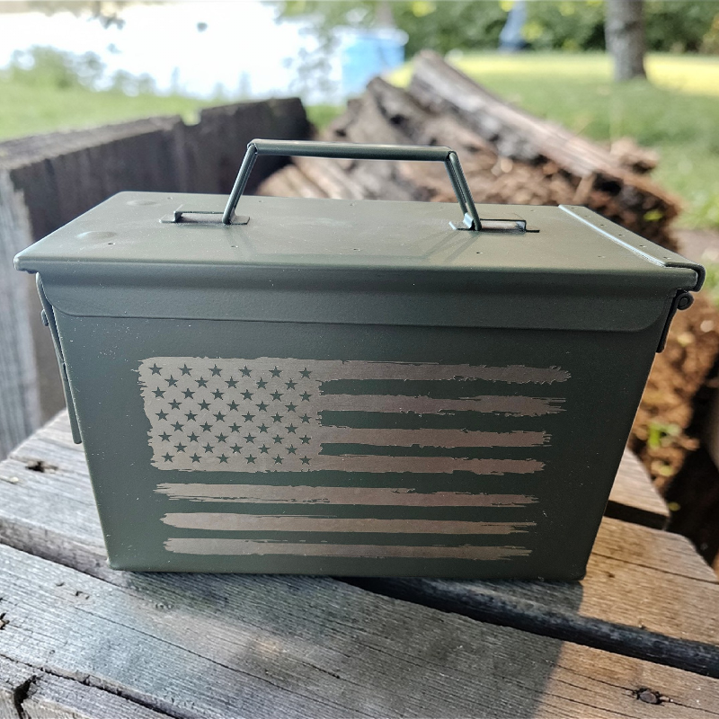 Metal box with American flag design on a wooden surface outdoors