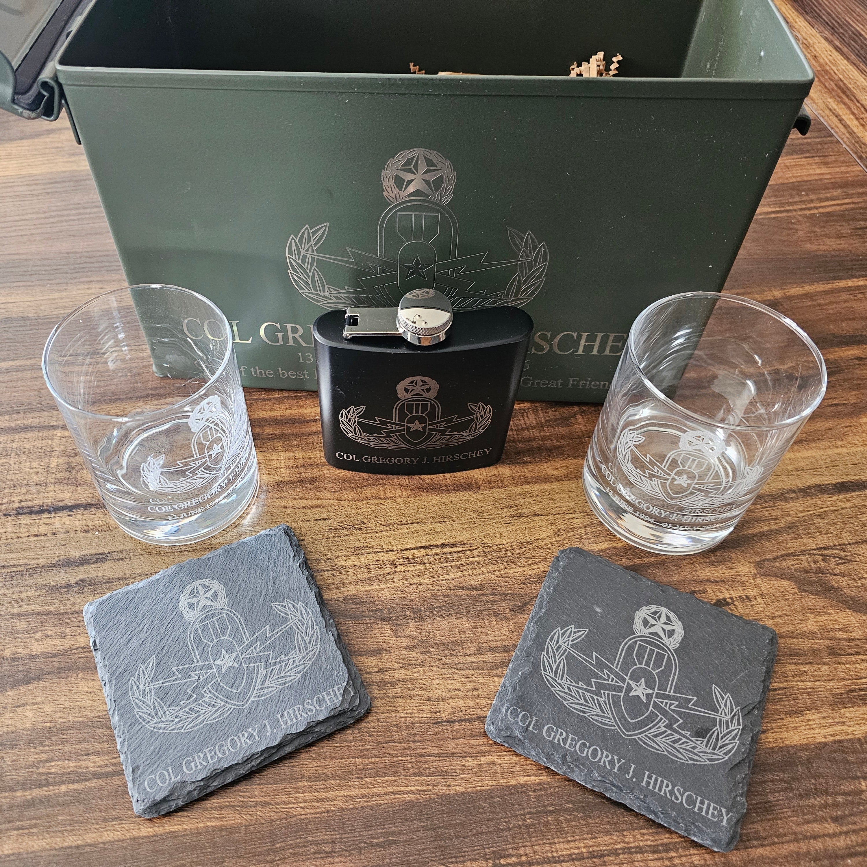 Cigar humidor with glasses, lighter, and coasters on a wooden surface
