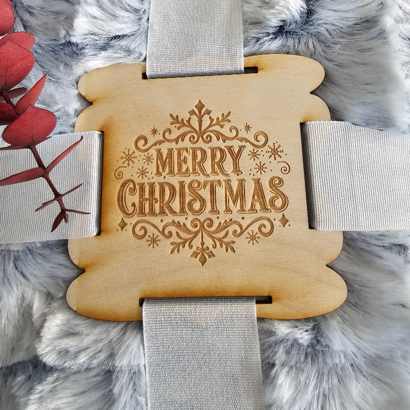 Wooden tag with 'Merry Christmas' engraving on a fluffy gray background