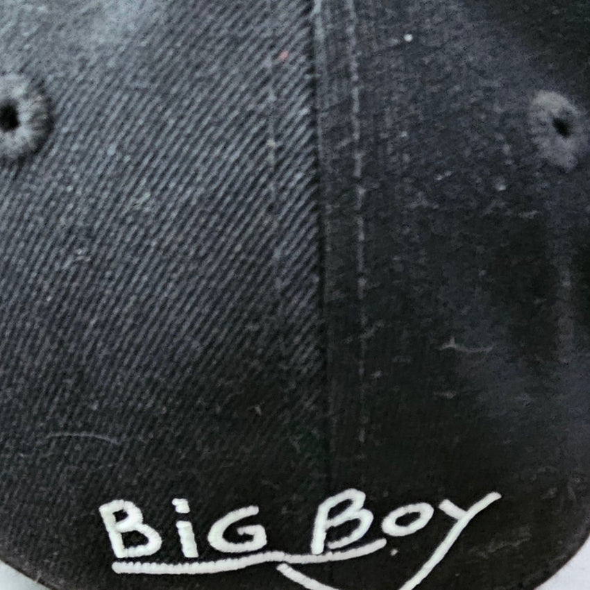 Close-up of the back of a black baseball cap with 'Big Boy' embroidered in white script on the lower panel.