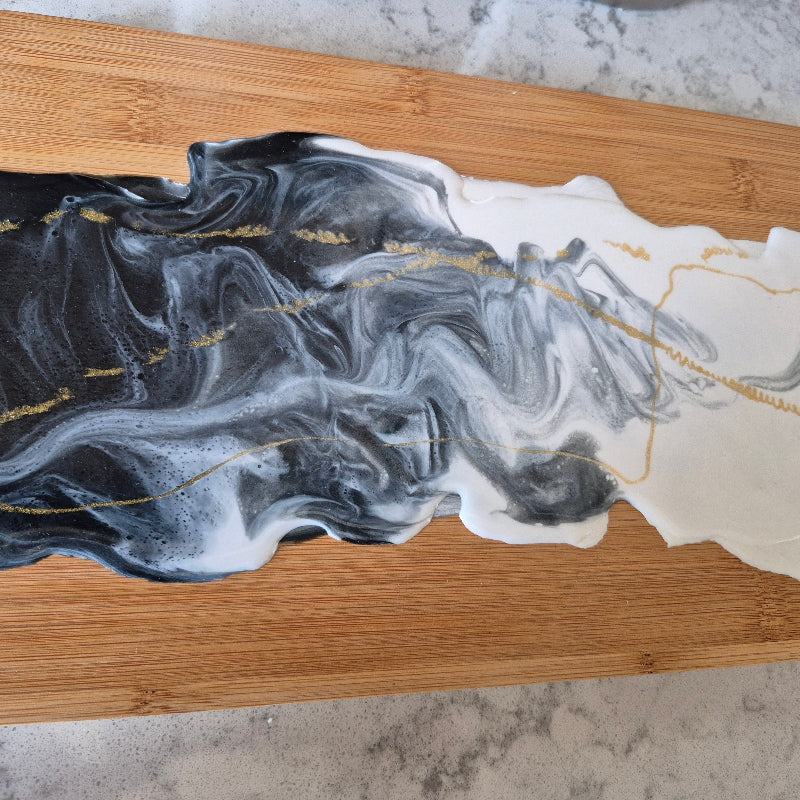 Decorative piece with wavy black and white design on a wooden base