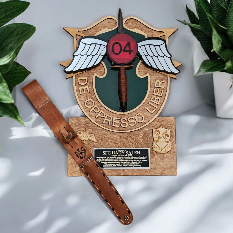 Wooden plaque with emblem and leather strap on a light surface with plants