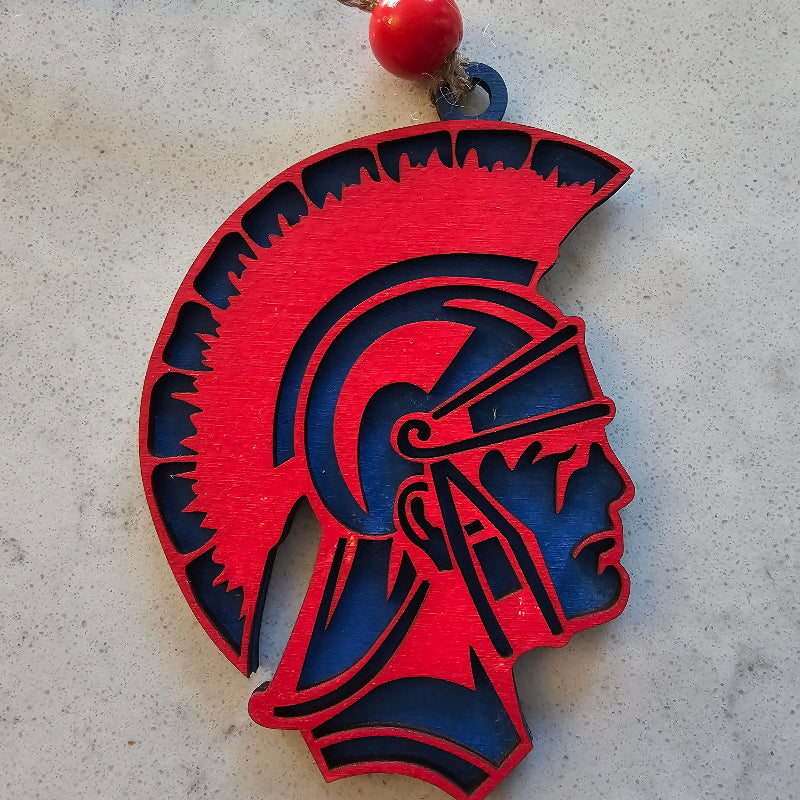 Red and blue decorative item with a string on a gray surface