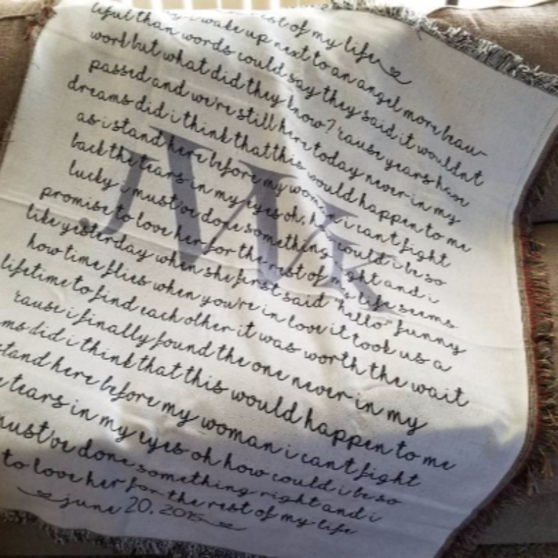 Textile with embroidered text on a beige couch