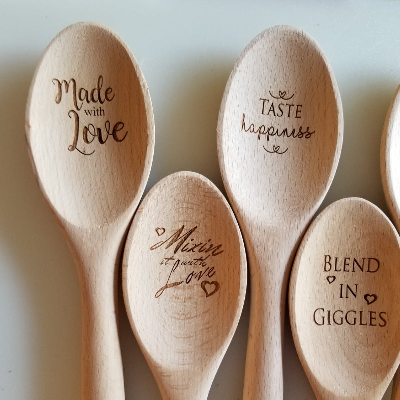 Wooden spoons with engraved text on a light background